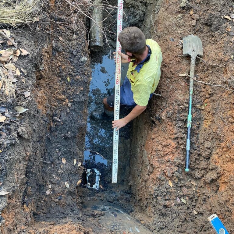 Plumber measuring soil depth — Plumbing Contractors in Brisbane, QLD