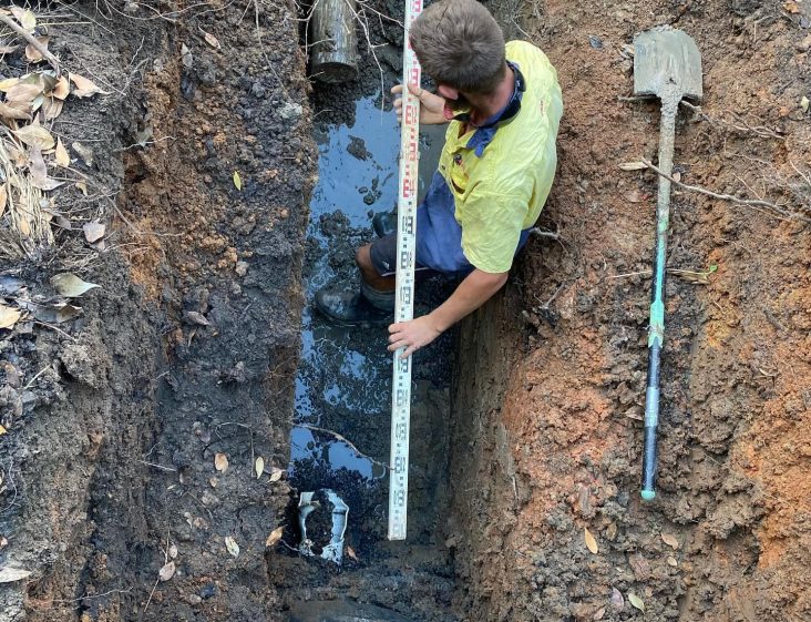 Plumber measuring soil depth — Plumbing Contractors in Beerwah, QLD