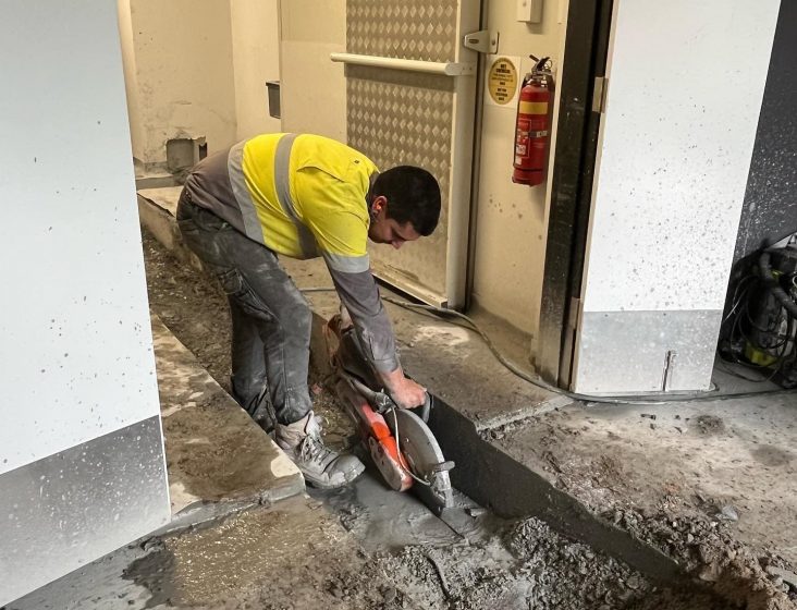 Plumber working on floor cutting — Plumbing Contractors in Brisbane, QLD