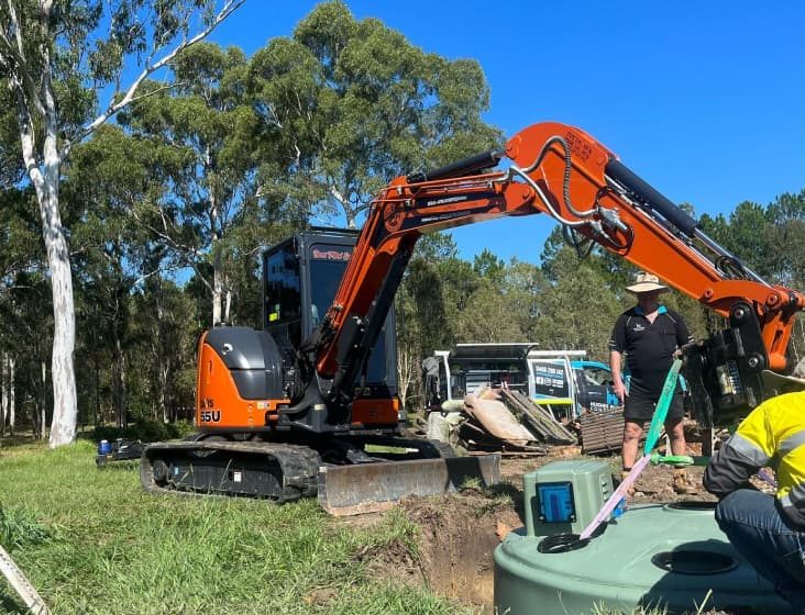 Orange excavator — Plumbing Contractors in Brisbane, QLD