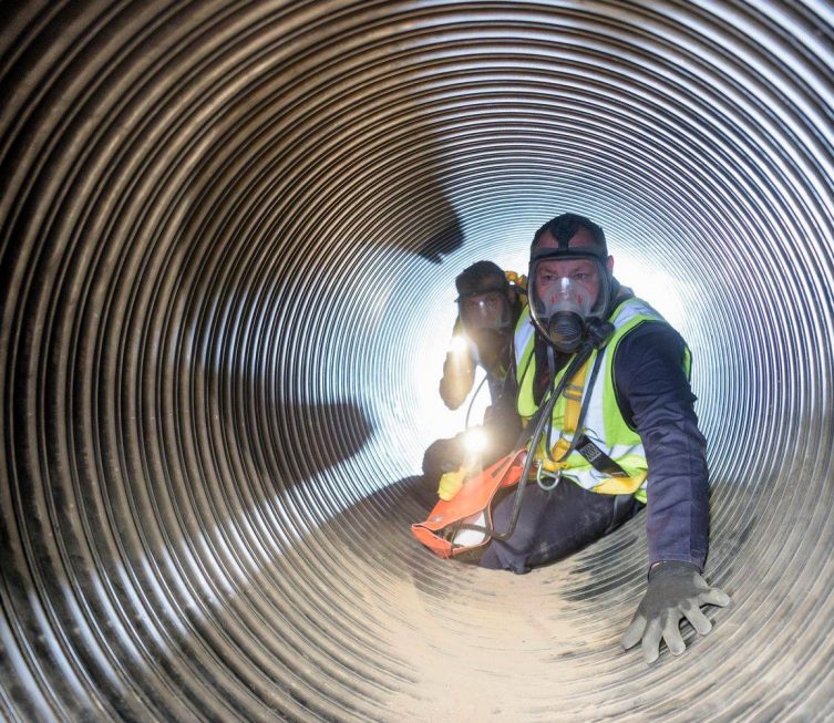 Plumbers working on a confined space — Plumbing Contractors in Brisbane, QLD
